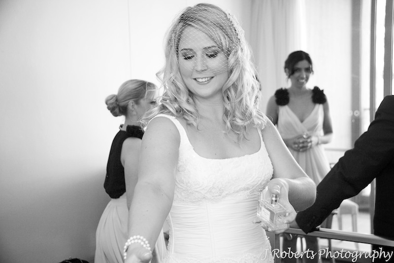 Bride spraying perfume as her final touch - wedding photography sydney
